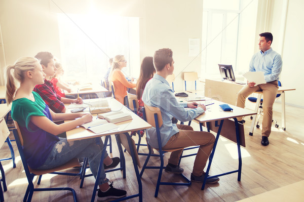 group of students and teacher with papers or tests Stock photo © dolgachov