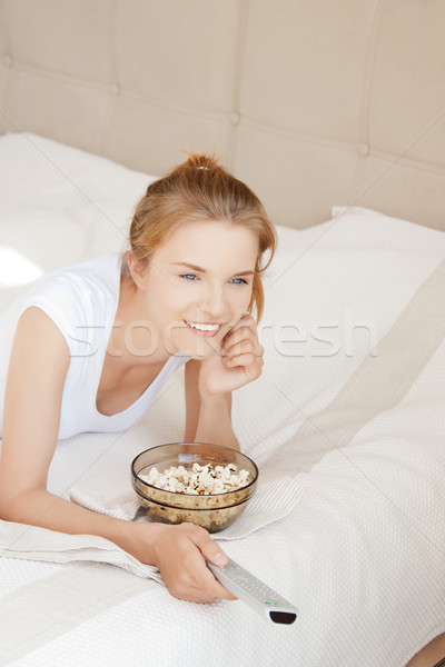 happy teenage girl with TV remote and popcorn Stock photo © dolgachov