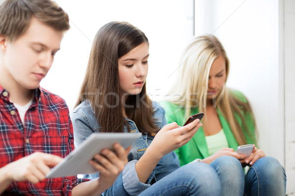 Estudantes olhando dispositivos escolas educação telefones Foto stock © dolgachov