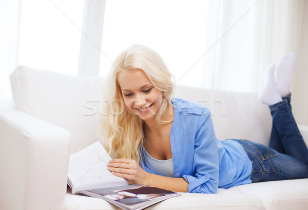 женщину диване чтение журнала домой улыбающаяся женщина Сток-фото © dolgachov
