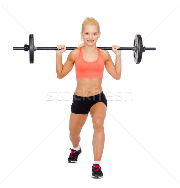 Stock photo: smiling sporty woman exercising with barbell