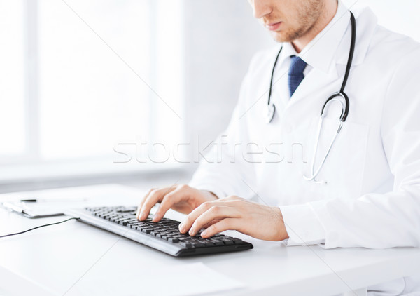 Stock photo: male doctor typing  on the keyboard