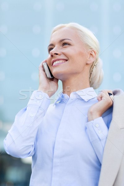Stock photo: smiling businesswoman with smartphone outdoors