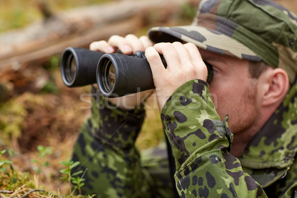 Stock photo: young soldier or hunter with binocular in forest