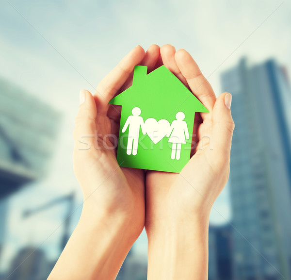 Stock photo: hands holding green house with family