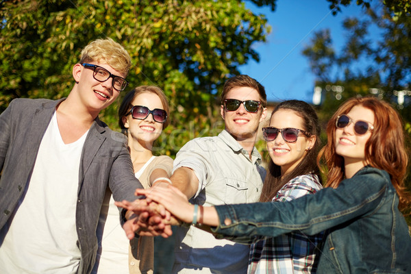 group of students or teenagers with hands on top Stock photo © dolgachov