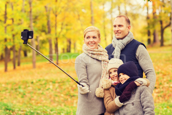 happy family with smartphone and monopod in park Stock photo © dolgachov