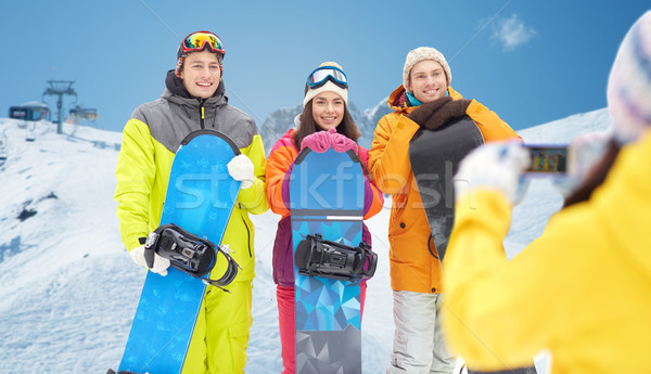 happy friends with snowboards and smartphone Stock photo © dolgachov