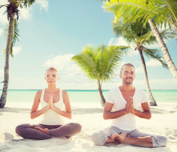 Souriant couple méditer plage tropicale sport yoga [[stock_photo]] © dolgachov