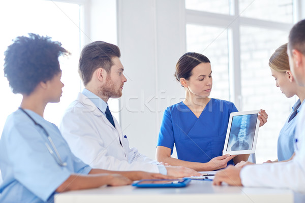 group of doctors with x-ray on tablet pc at clinic Stock photo © dolgachov