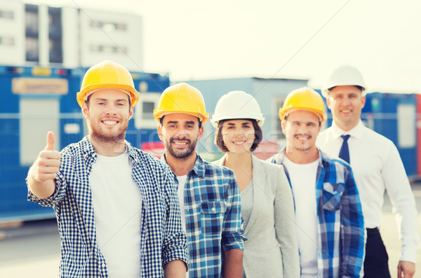 Stock photo: group of smiling builders in hardhats outdoors