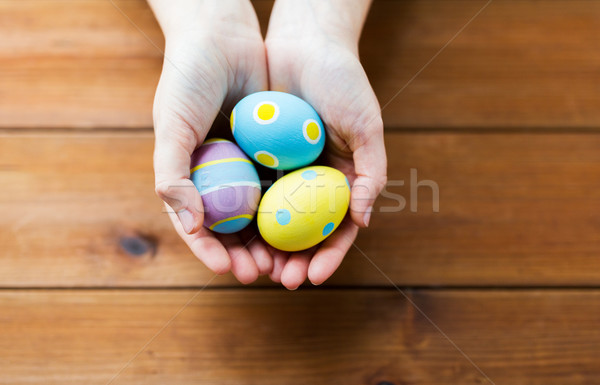 Stock photo: close up of woman hands with colored easter eggs