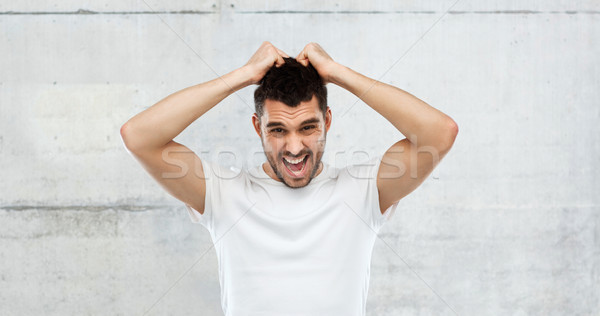 crazy shouting man in t-shirt over gray background Stock photo © dolgachov