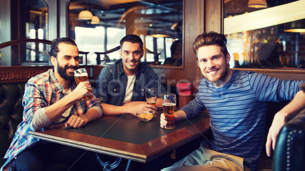 Fericit masculin prietenii potabilă bere bar Imagine de stoc © dolgachov