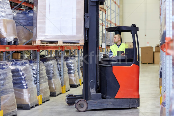 man with tablet pc operating forklift at warehouse Stock photo © dolgachov