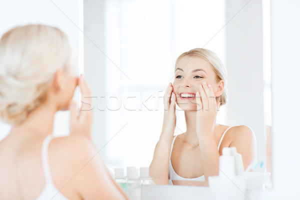 Boldog nő jelentkezik krém arc fürdőszoba Stock fotó © dolgachov