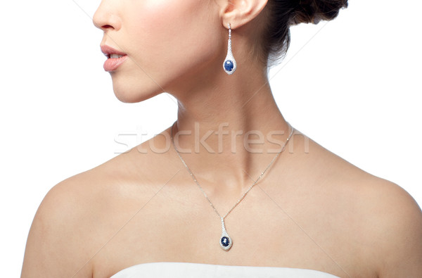 close up of woman with earring and pendant Stock photo © dolgachov