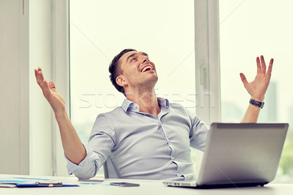 happy businessman with laptop in office Stock photo © dolgachov