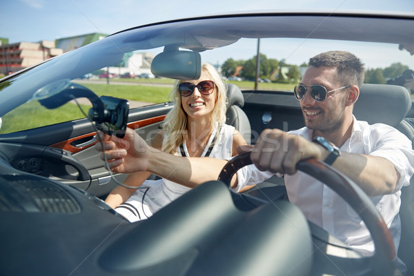 happy couple using gps navigator in cabriolet car Stock photo © dolgachov