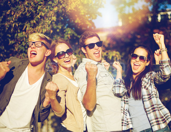 group of happy friends showing triumph gesture Stock photo © dolgachov
