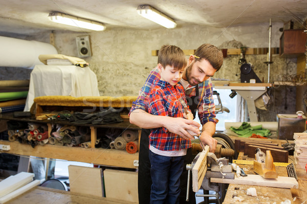 father and son with chisel working at workshop Stock photo © dolgachov