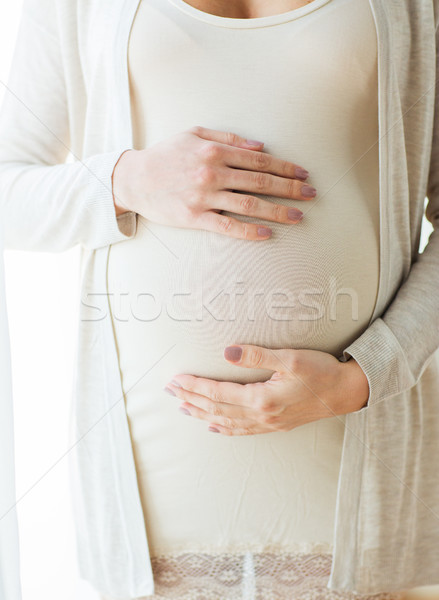 close up of pregnant woman belly and hands Stock photo © dolgachov