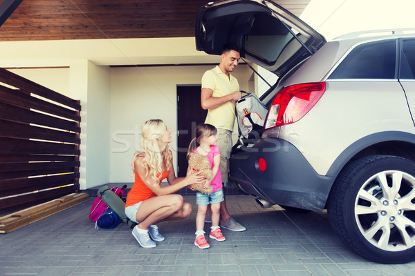 happy family packing things to car at home parking Stock photo © dolgachov
