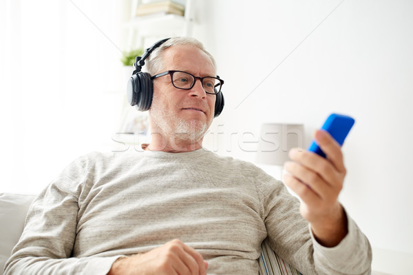 Stockfoto: Gelukkig · senior · man · smartphone · hoofdtelefoon · technologie