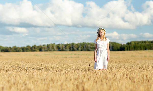 happy young woman in flower wreath on cereal field Stock photo © dolgachov