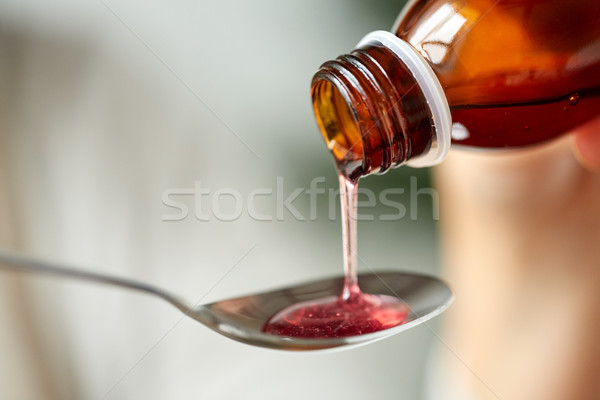 medication or antipyretic syrup and spoon Stock photo © dolgachov