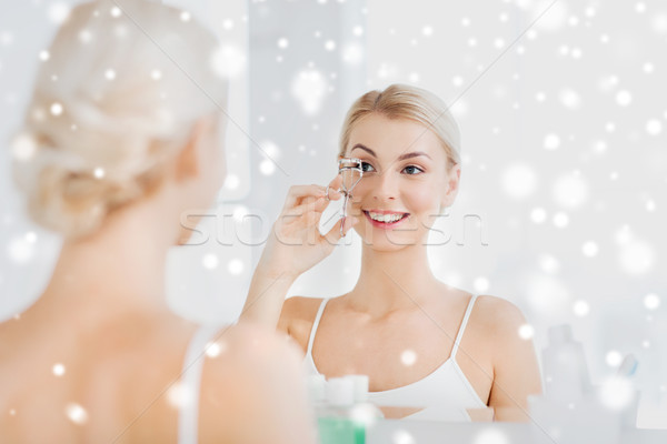 woman with curler curling eyelashes at bathroom Stock photo © dolgachov