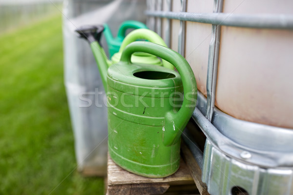 watering cans at farm water tank Stock photo © dolgachov