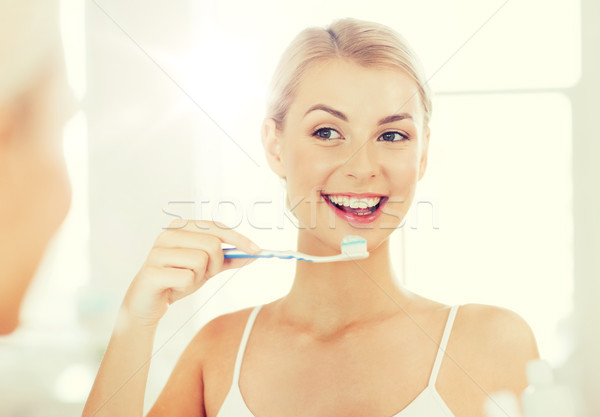 Femme brosse à dents nettoyage dents salle de bain [[stock_photo]] © dolgachov