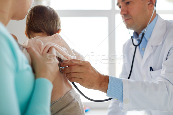 doctor with stethoscope listening baby at clinic Stock photo © dolgachov
