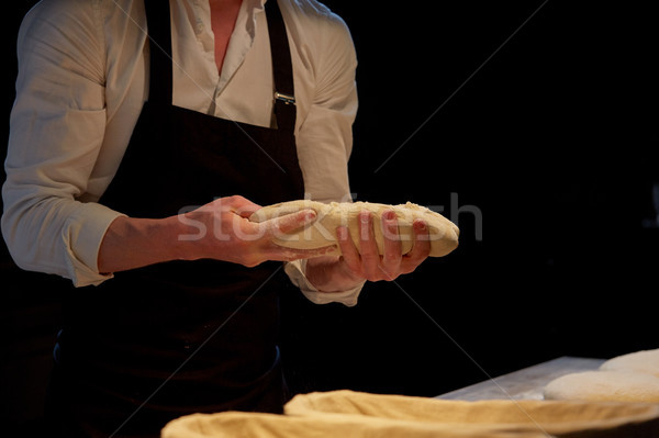 baker with dough rising in baskets at bakery Stock photo © dolgachov