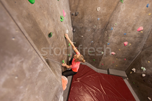 Stock photo: young woman exercising at indoor climbing gym