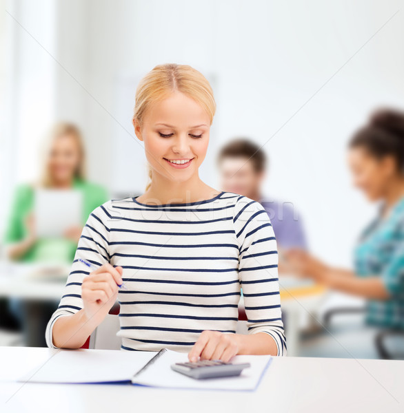 woman with notebook and calculator studying Stock photo © dolgachov