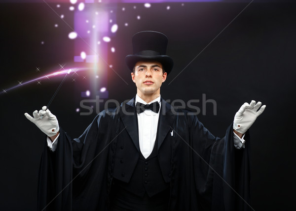 magician in top hat with magic wand showing trick Stock photo © dolgachov