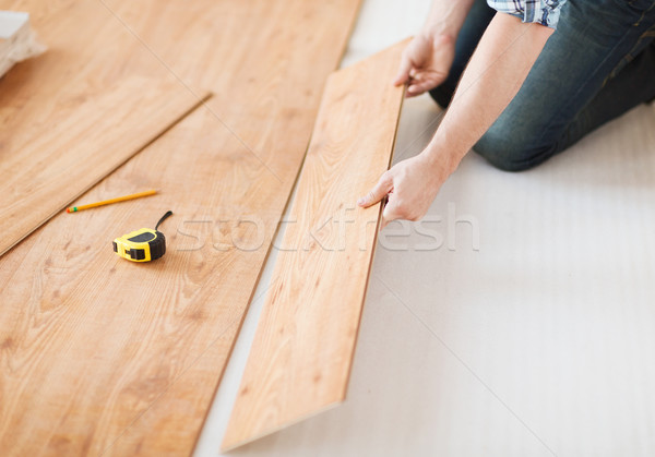 Stock photo: close up of male hands intalling wood flooring