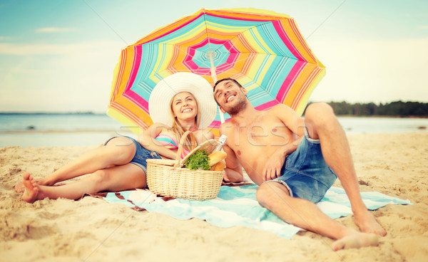 Mosolyog pár napozás tengerpart nyár ünnepek Stock fotó © dolgachov