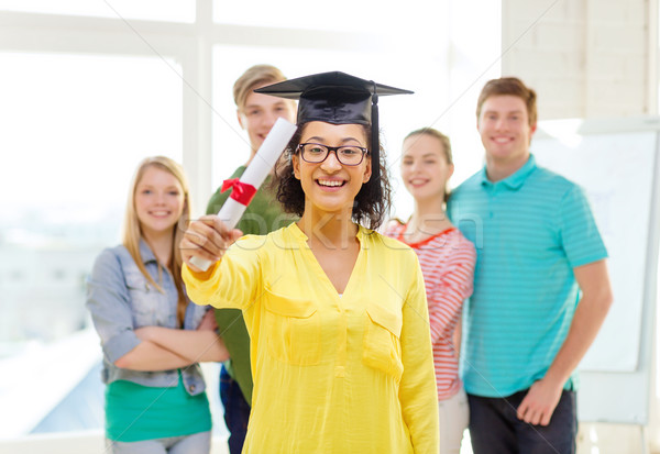smiling female student with diploma and corner-cap Stock photo © dolgachov