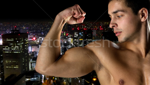 close up of young man showing biceps Stock photo © dolgachov