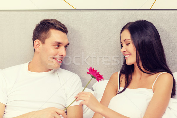smiling couple in bed with flower Stock photo © dolgachov
