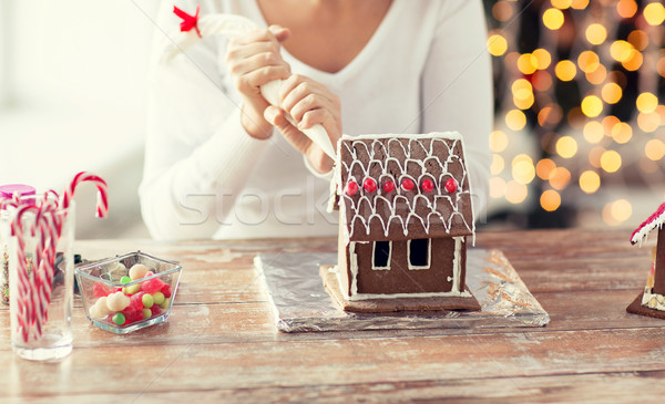 Stock photo: close up of woman making gingerbread house at home