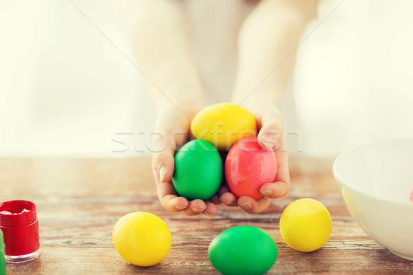 Stock photo: close up of girl holding colored eggs