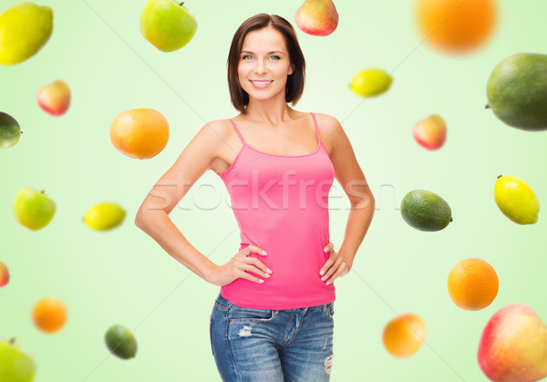 woman in blank pink tank top over fruits on green Stock photo © dolgachov