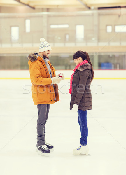 happy couple with engagement ring on skating rink Stock photo © dolgachov