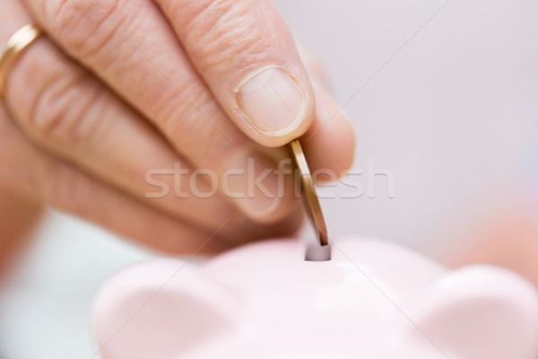 senior woman hand putting money to piggy bank Stock photo © dolgachov