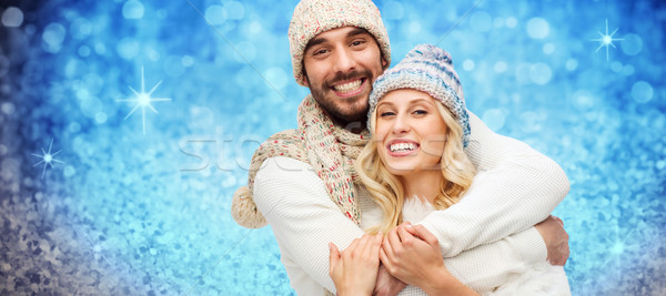 Stock photo: happy couple in winter clothes hugging over lights