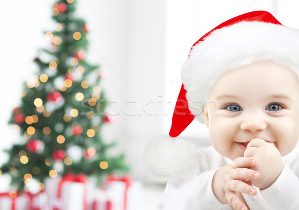 happy baby in santa hat over christmas tree lights Stock photo © dolgachov